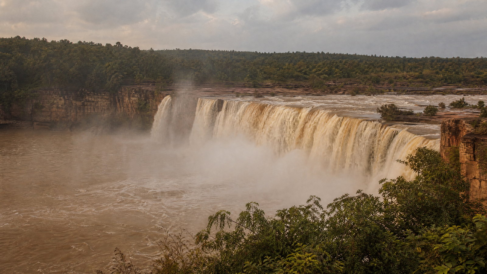 Chitrakote Falls spreading in a broad horseshoe over the Indravati River amid dense green Bastar forest.