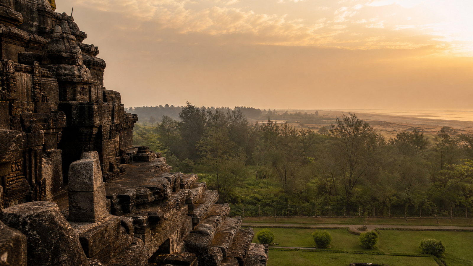 Dawn light across a carved stone wheel and terraces of Konark Sun Temple, Odisha