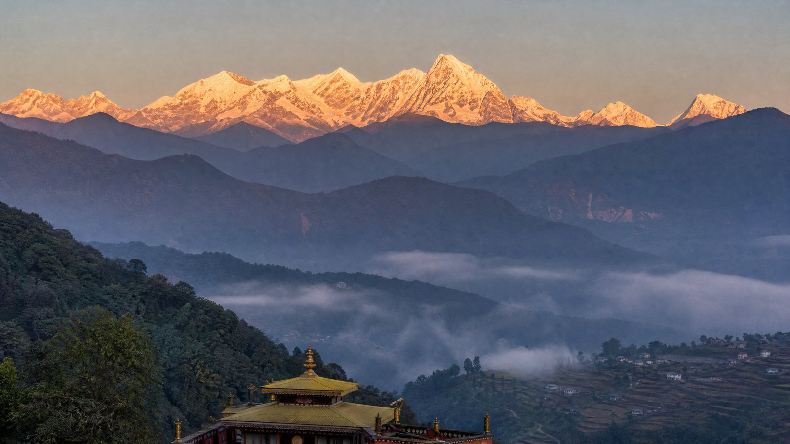 Clouds lifting from forested ridges toward the snow-covered Khangchendzonga massif in western Sikkim.
