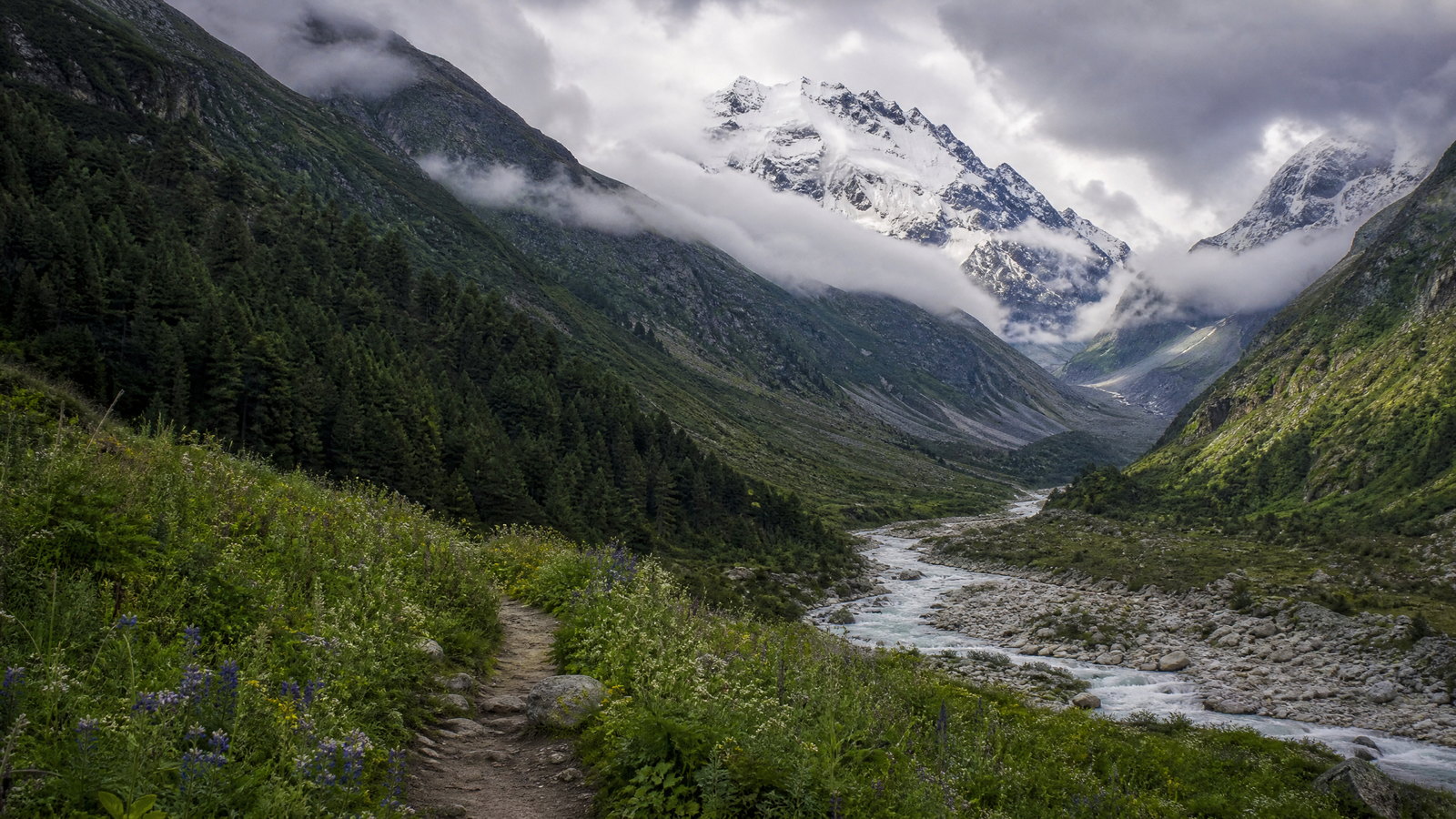 Early light on the stone Kedarnath Temple beneath snow-streaked Garhwal peaks, viewed across a quiet alpine valley.