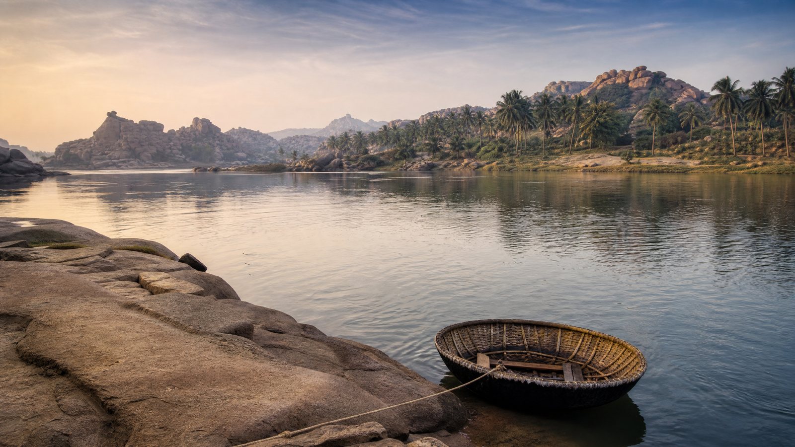A coracle beside the Tungabhadra River with Hampi's granite hills beyond