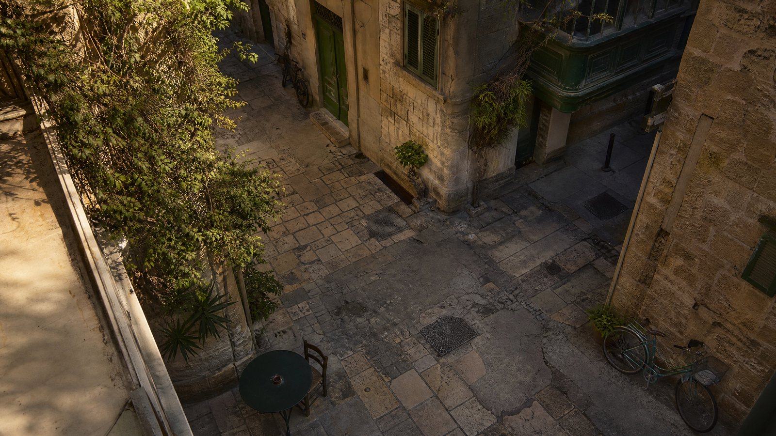 A quiet café table beside a sunlit city street